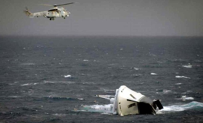 In this Greek Coast Guard photo released on Friday, Feb. 17, 2012, a Greek air force helicopter flies over a half sunken 60-meter French-flagged yacht which suffered mechanical failure in gale-force winds off the coast of the Aegean island of Skyros, Greece. The coast guard said two Air Force helicopters and a Navy frigate, as well as coast guard vessels and four commercial ships headed to the assistance of the yacht, registered as Yogi, after its captain sent out a distress signal Friday mornin ©  SW
